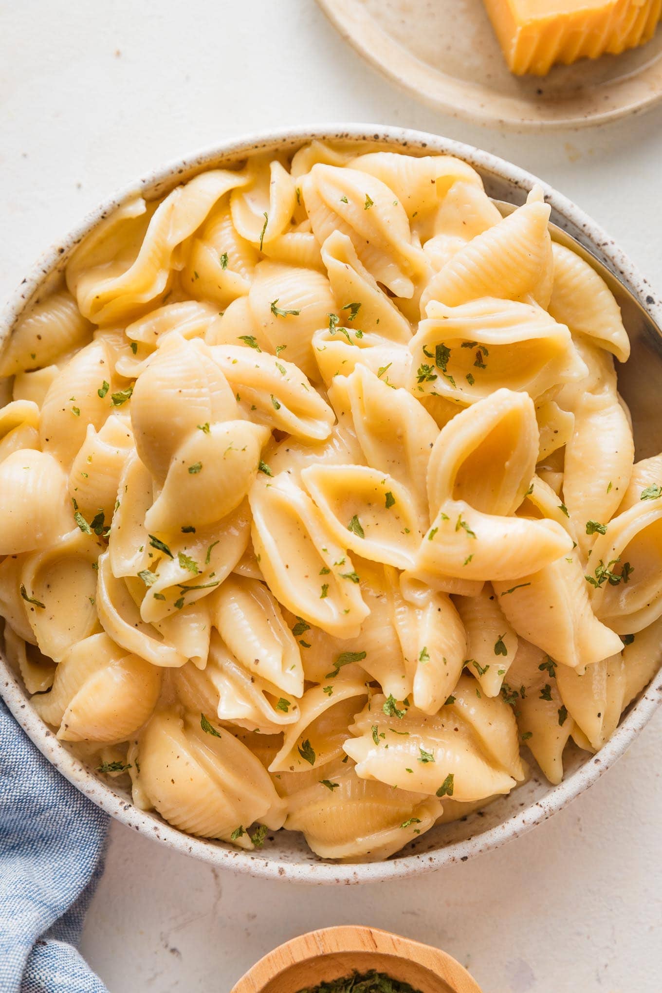 Close up of a spoon scooping out a portion of Instant Pot mac and cheese from a small serving bowl.