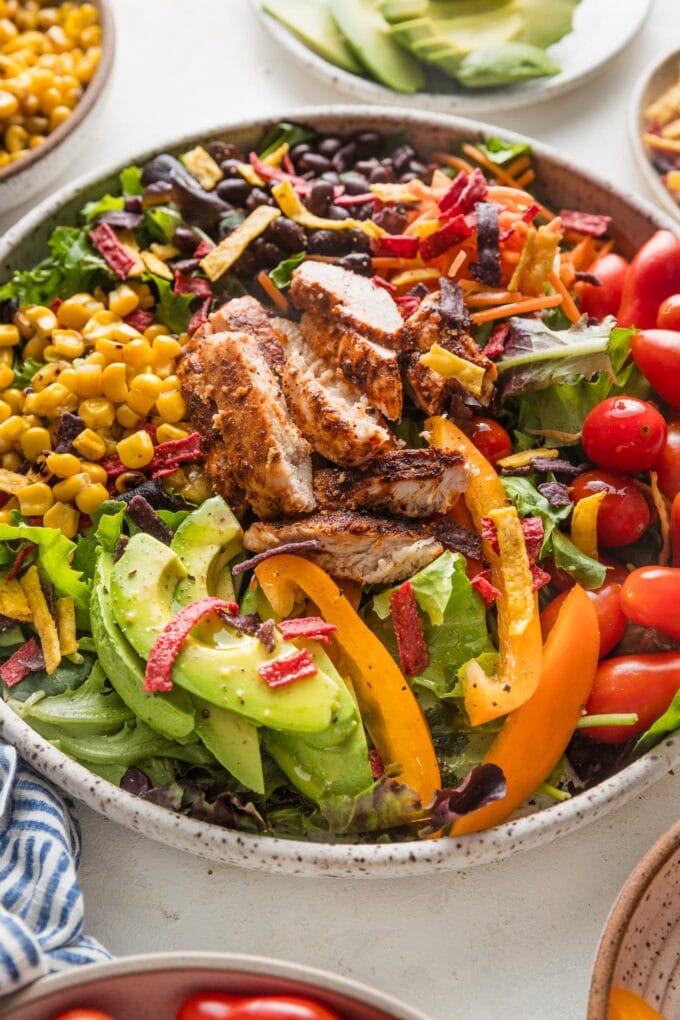 Angled view of a large southwest-style salad with black beans and chicken.