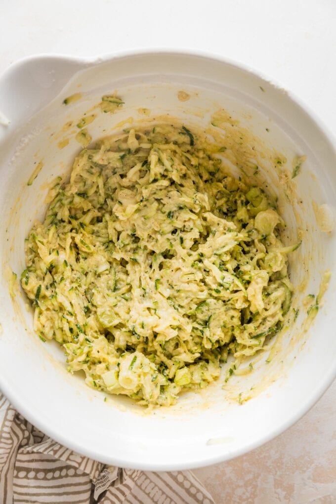 Flour and baking powder folded into egg-zucchini mixture and ready to scoop out into fritters.