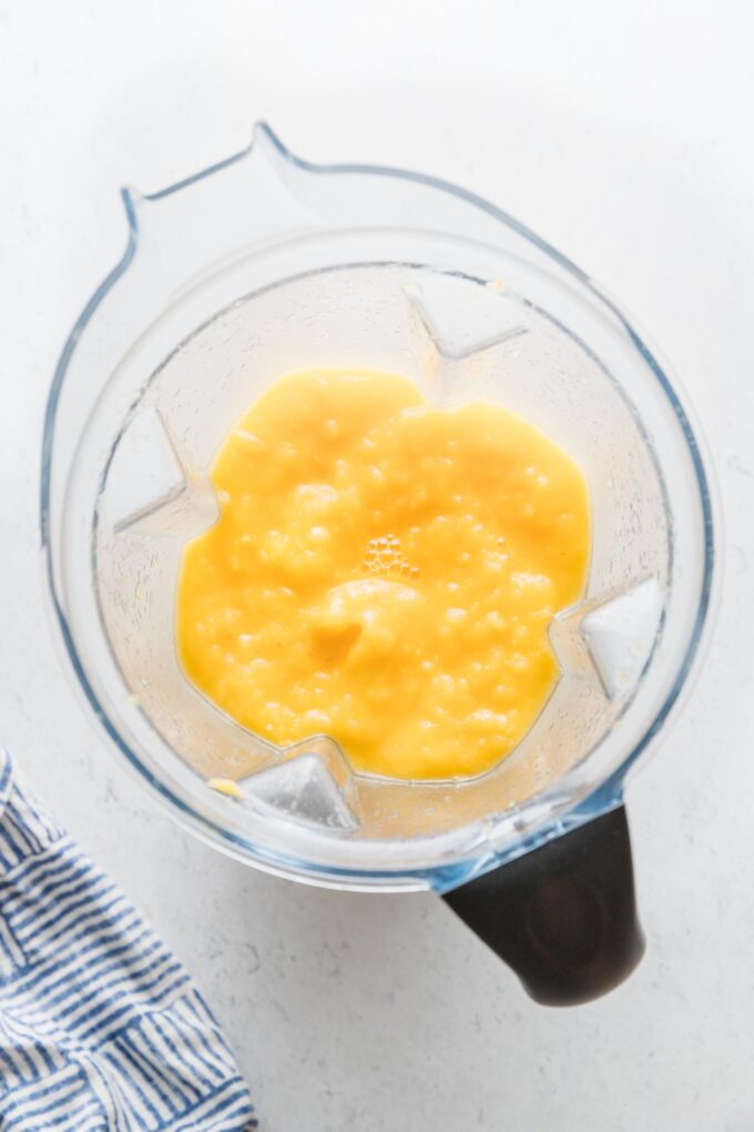 Large blender full of a frozen mango lemonade.