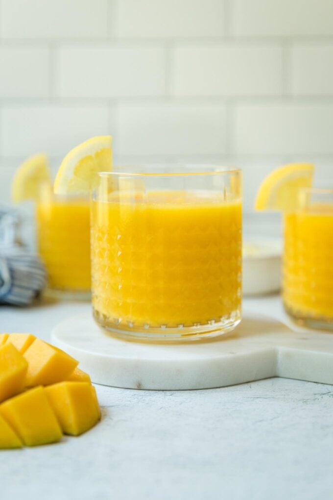Straight on view of mango frozen lemonade served in small clear glasses.
