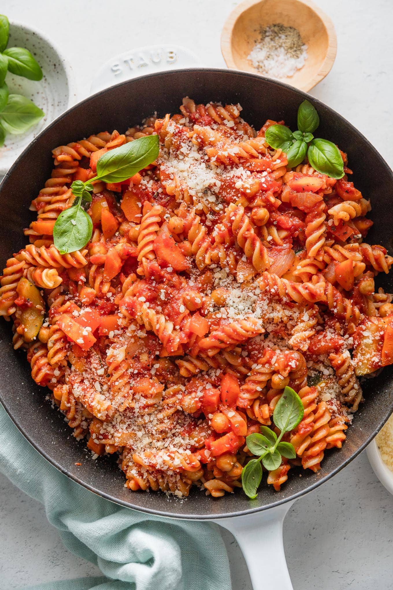 Skillet full of veggie pasta marinara with zucchini, carrot, onion, and bell pepper.