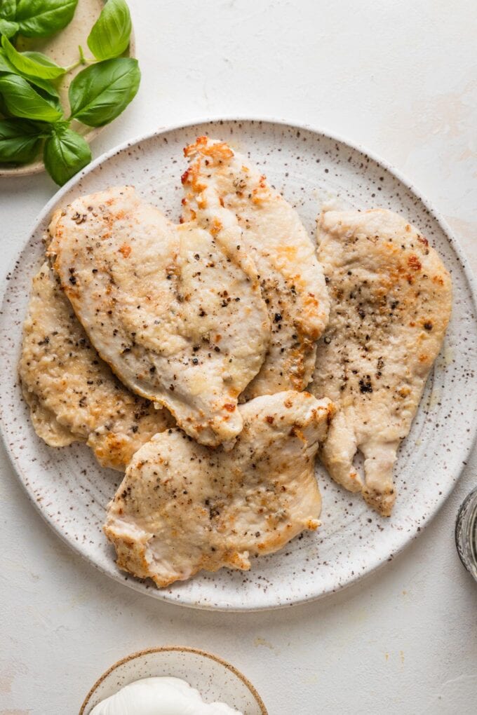 Pan-seared chicken breasts resting on a plate.