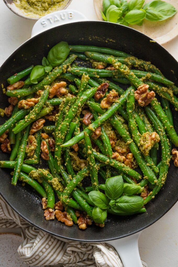 Overhead view of a small white cast iron skillet filled a side dish of pesto green beans.