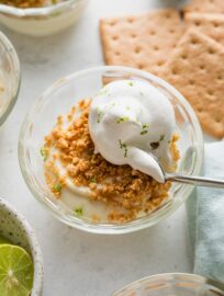 Small custard dish with an individual portion of no bake key lime pie served "upside down," with graham cracker crumbs on top.