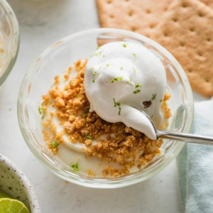 Small custard dish with an individual portion of no bake key lime pie served "upside down," with graham cracker crumbs on top.