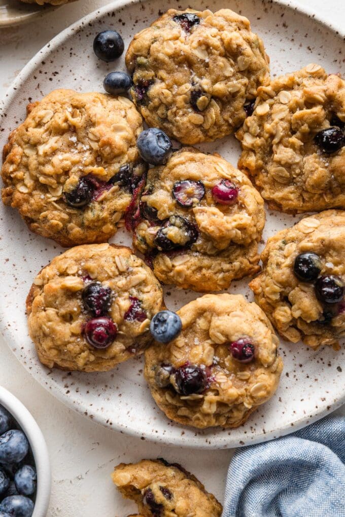 Close up of tender, chewy blueberry oatmeal cookies on a small white plate.