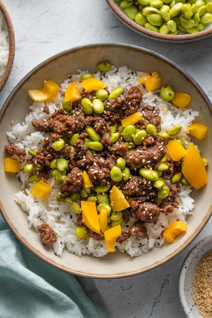 Ground beef bowl with edamame, bell pepper, and sesame seeds served over jasmine rice.