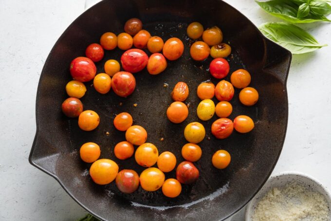 Lightly burst cherry tomatoes in a cast iron skillet.