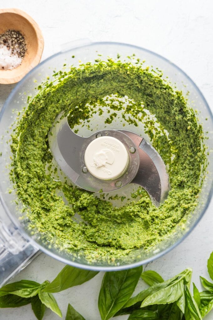 Food processor bowl filled with homemade spinach pesto.