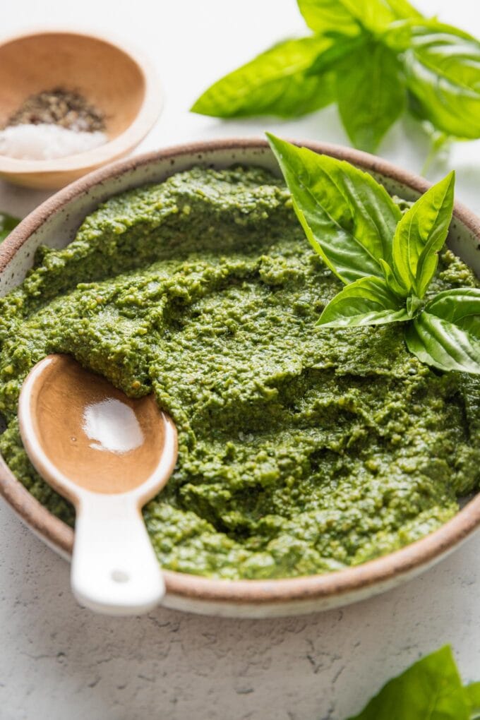 Angled view of a small bowl filled with spinach basil pesto.