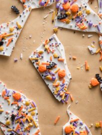 Parchment paper with white chocolate "boo bark" pieces scattered on top.