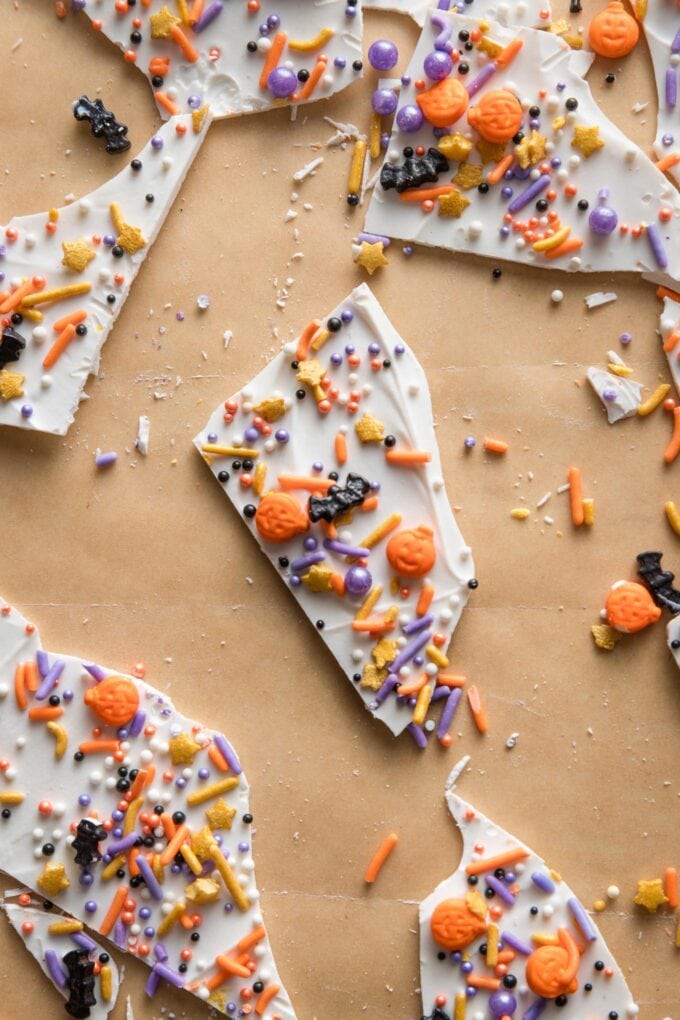 Parchment paper with white chocolate "boo bark" pieces scattered on top.