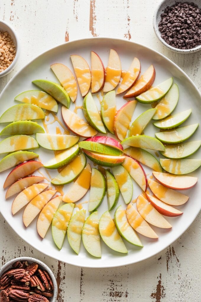Caramel drizzled on top of thinly-sliced apples.