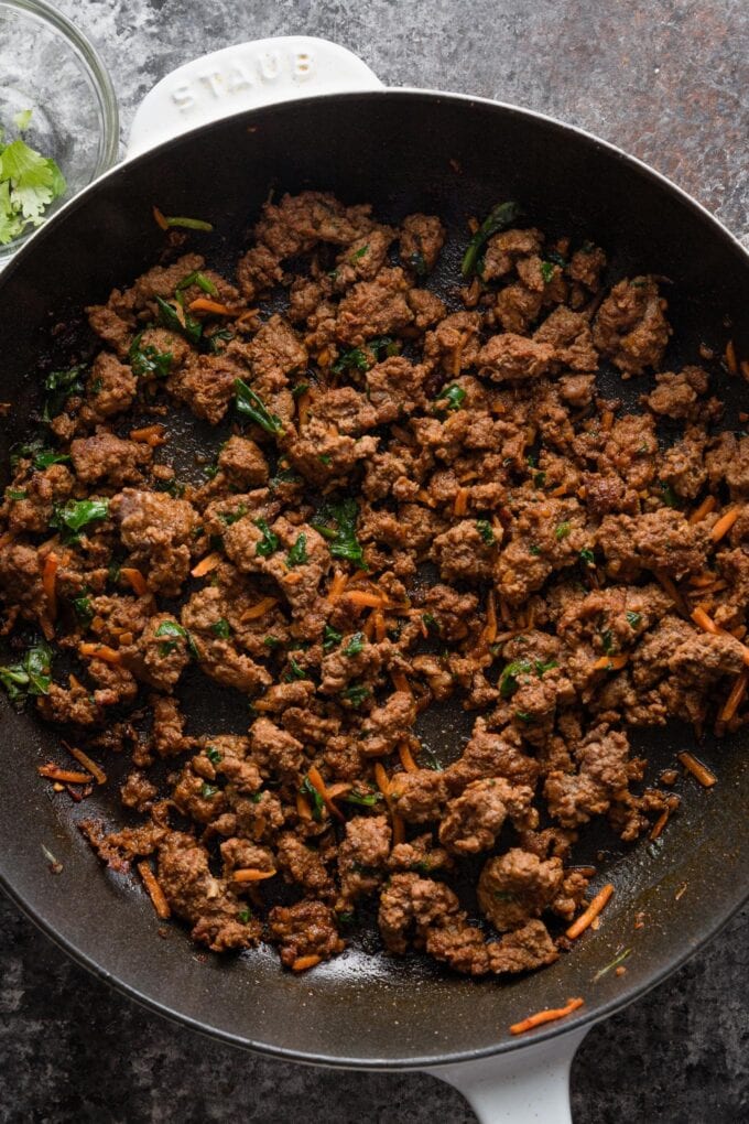 Small cast iron skillet full of seasoned taco meat.