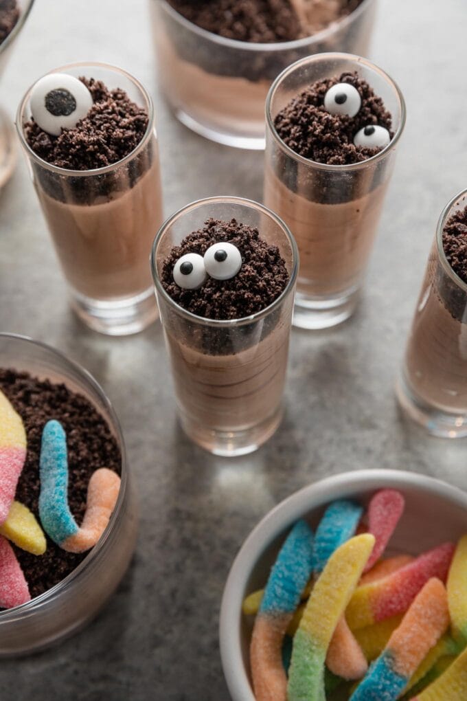 Small batch of Halloween dirt cup shooters, with chocolate pudding, crushed Oreos, and candy eyeballs.