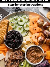 Assemble this cute Halloween-inspired fruit and cheese board with a variety of snacks and a few simple accessories. Share it as an appetizer at the neighborhood party or use it as an easy grazing dinner before the kids scoot off to trick or treat!