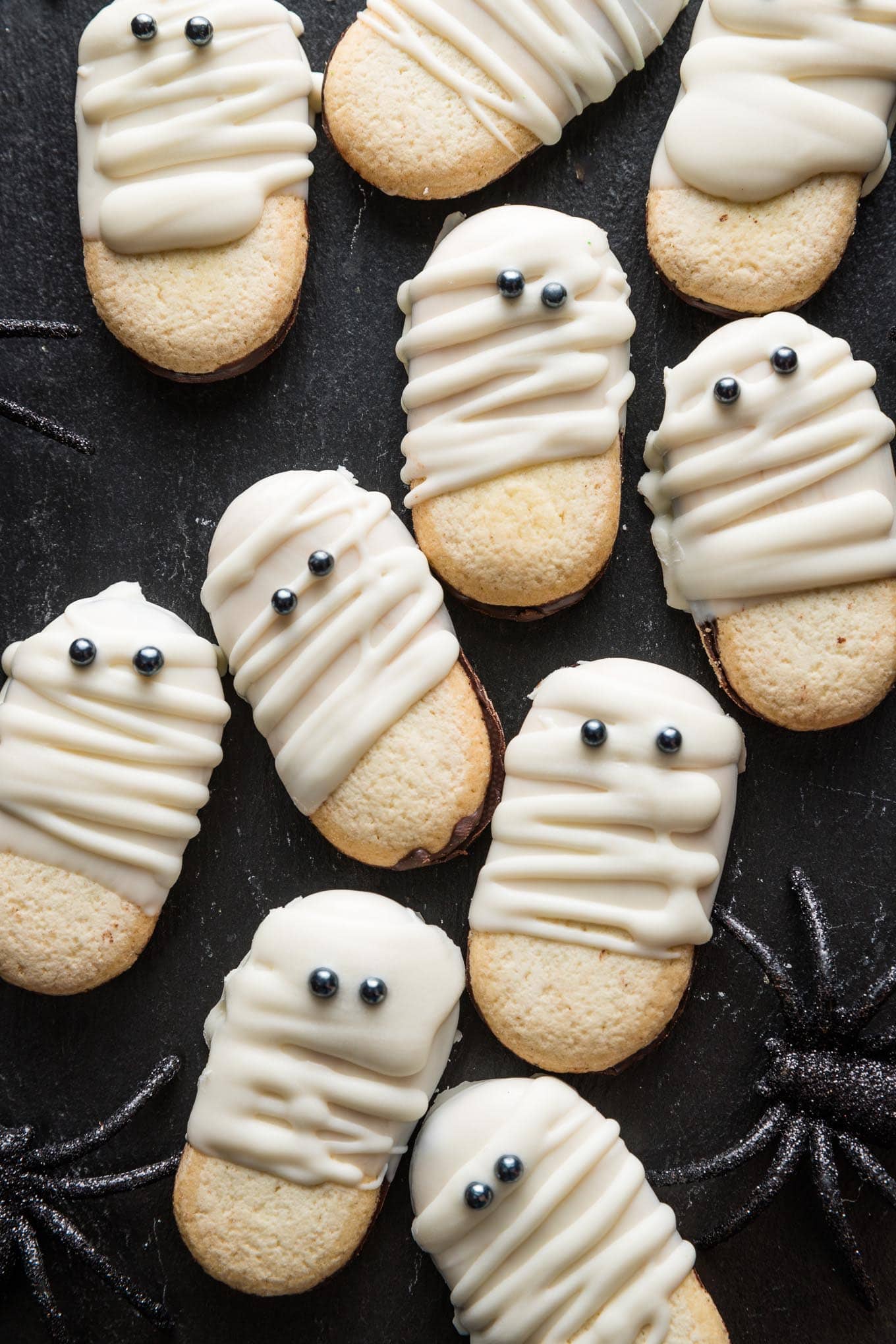 Tray of Milano cookies dipped and decorated with white chocolate to look like cute, spooky Mummies for a Halloween treat.