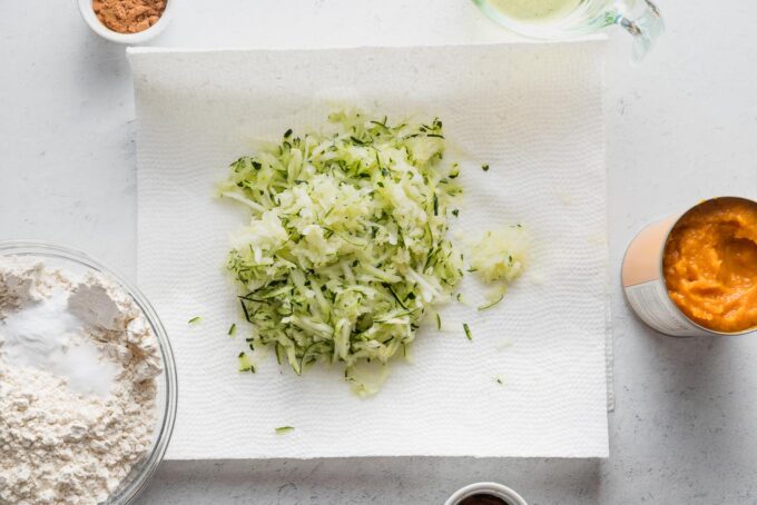 Grated zucchini resting on paper towels.