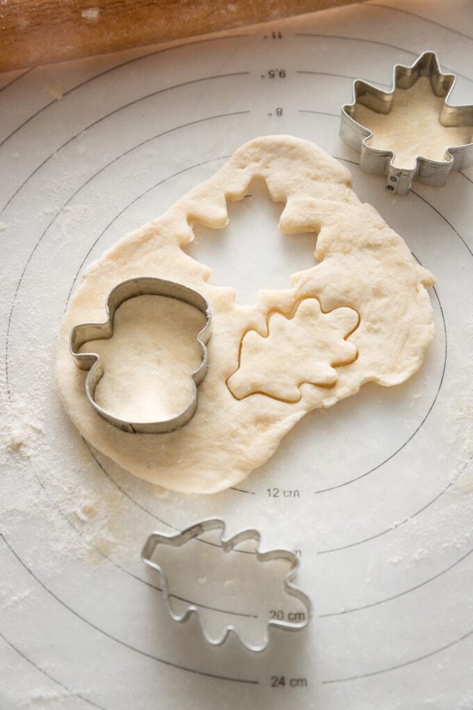 Small section of extra pie crust dough rolled out and cut into small festive shapes with pie and leaf shaped miniature cookie cutters.
