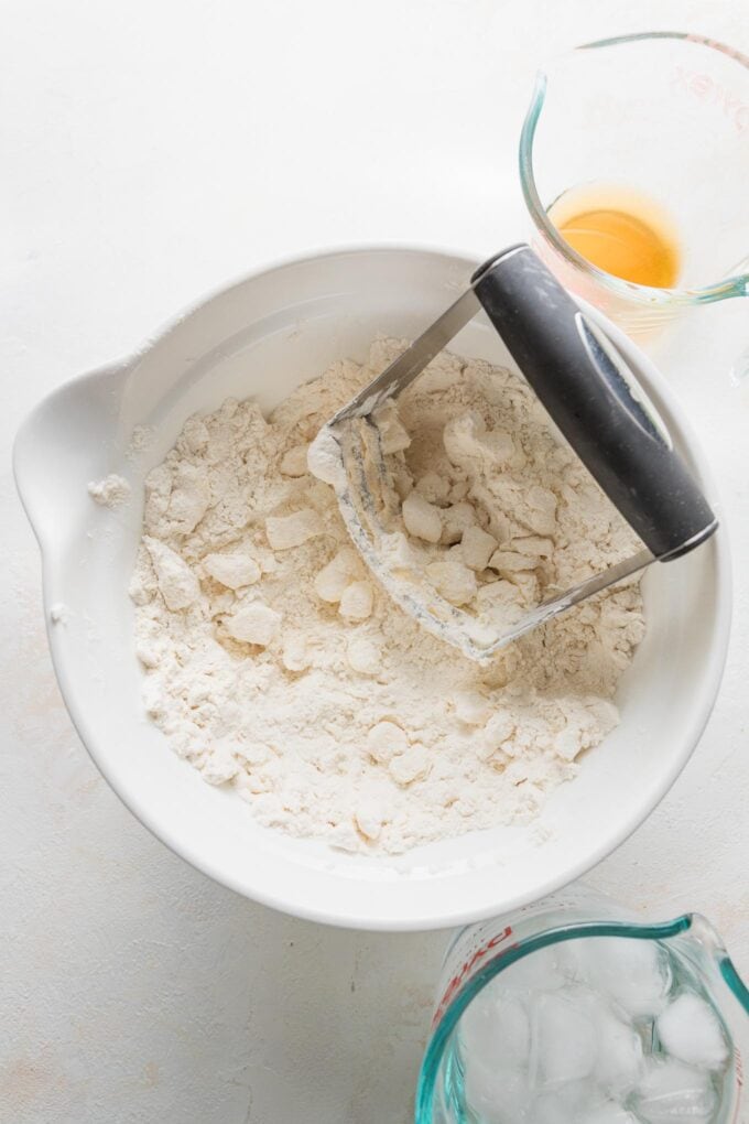Pastry blender in the process of cutting butter into pie dough.
