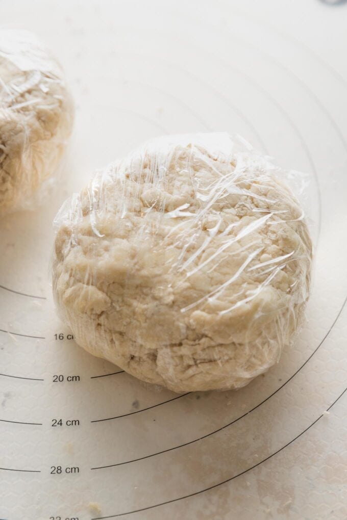 Pie crust wrapped in plastic wrap and ready to store in the refrigerator to mellow and chill.