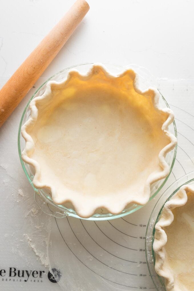 Homemade apple cider vinegar pie crust rolled out, pressed into a shell, and fluted around the edges.