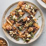 Small plate filled with fig, balsamic, and walnut flatbreads for a little appetizer.