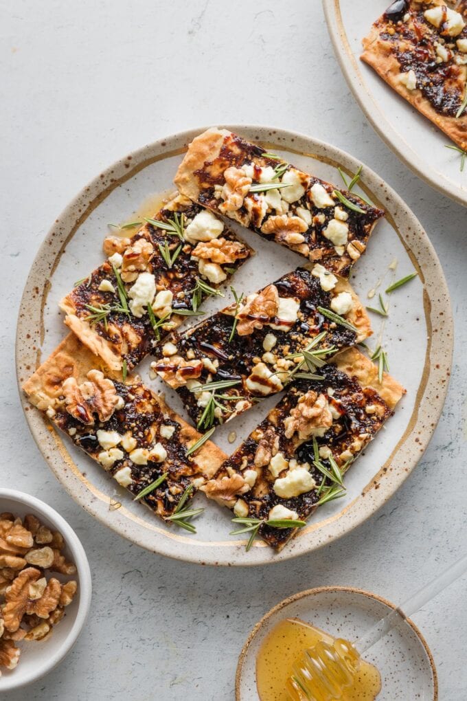 Small plate filled with fig, balsamic, and walnut flatbreads for a little appetizer.
