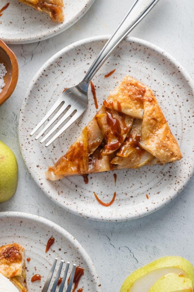 Small dessert plates with slices of pear caramel galette ready to serve.