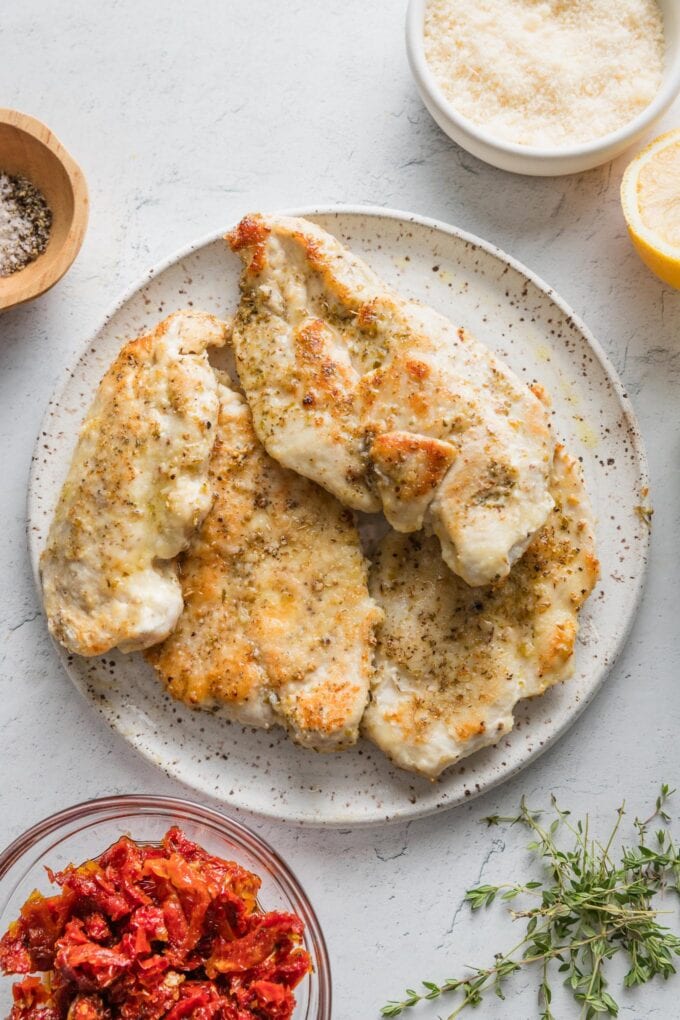 Browned chicken breasts resting on a plate.