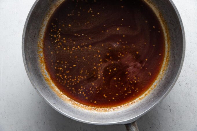 Sweet and sticky sauce for Asian meatballs, simmered in a large cast iron skillet.