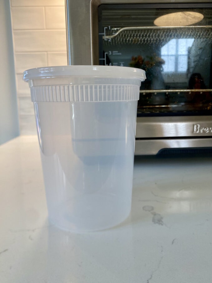 Empty deli container on a kitchen countertop.