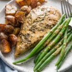 Dinner plate of creamy Dijon chicken, skillet-fried potatoes, and green beans, all dressed with a light Dijon cream sauce.