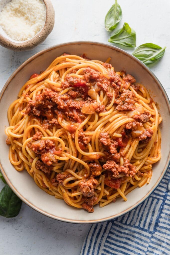 Ceramic pasta bowl full of Instant Pot spaghetti with meat sauce, twirled in large forkfuls.