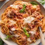 Spaghetti with meat sauce made in the Instant Pot, topped with fresh basil and fresh grated Parmesan.