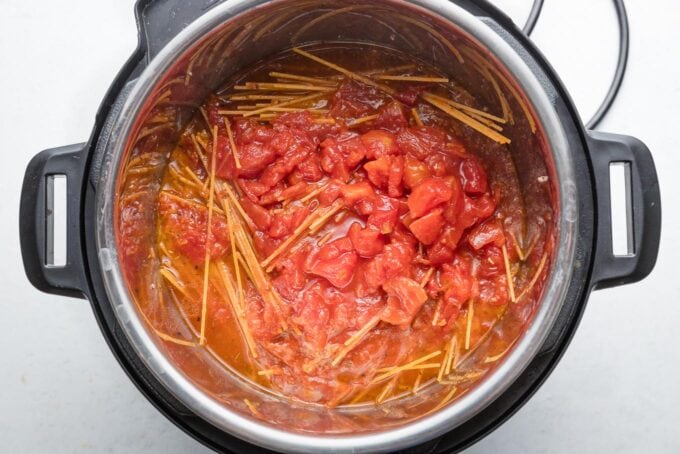 Liquid ingredients poured over dry spaghetti in Instant Pot.