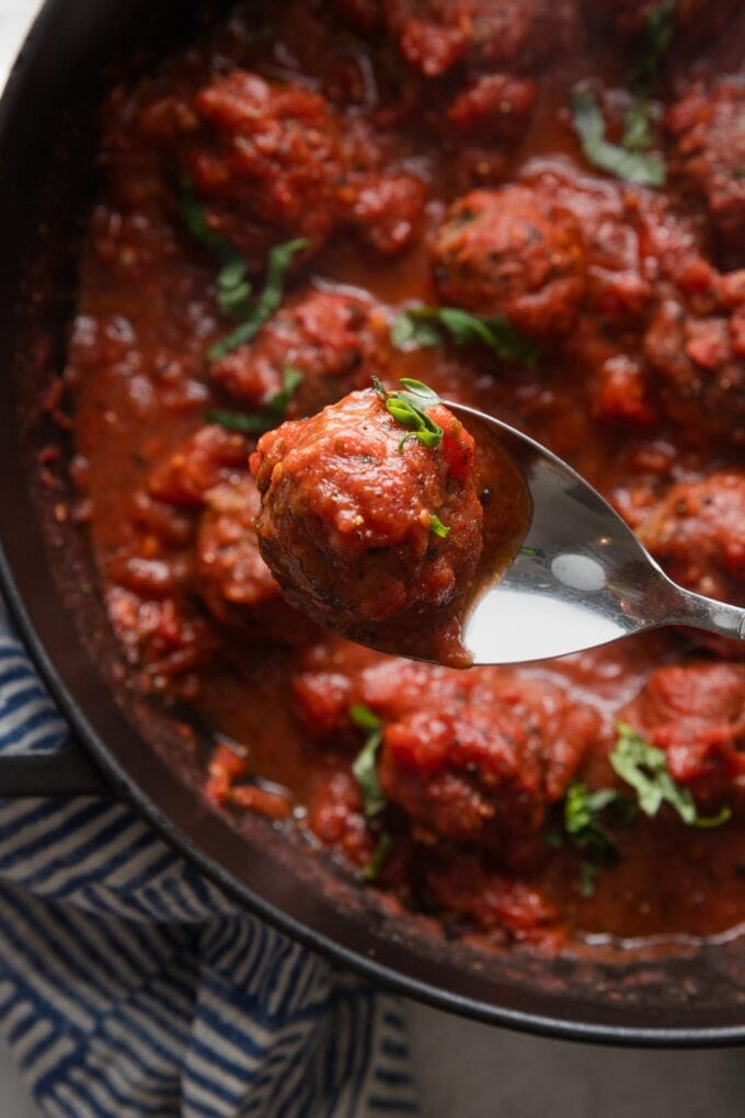 Close up of a homemade Italian meatball in marinara sauce.