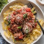 Close up of a small bowl filled with pasta and meatballs marinara.