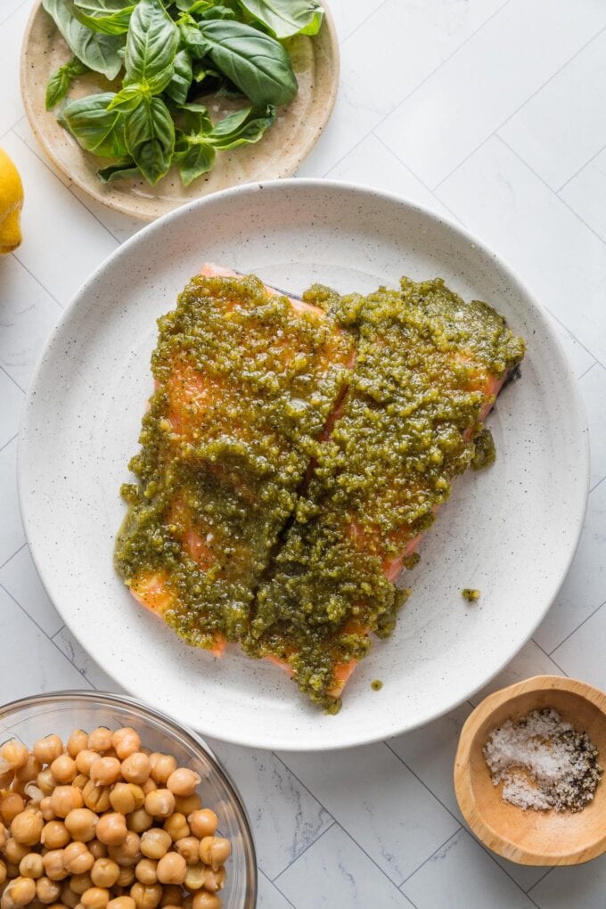 Two salmon filets slathered in basil pesto.