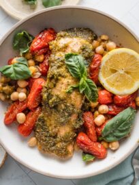 Pesto Salmon Bowls with Chickpeas are fresh, vibrant, and packed with flavor despite the simple ingredient list and minimal prep. Tender salmon is slathered in pesto and roasted alongside plump cherry tomatoes and creamy chickpeas for the most satisfying lunch or dinner. Easy to meal prep, as well.