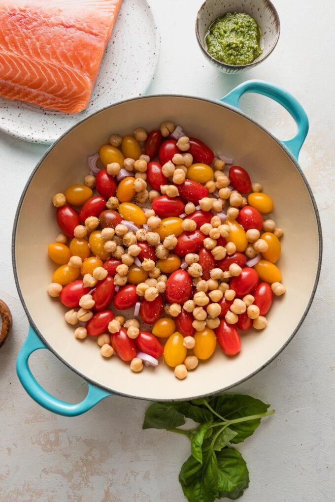 Tomatoes and chickpeas tossed together in a cast iron pan.
