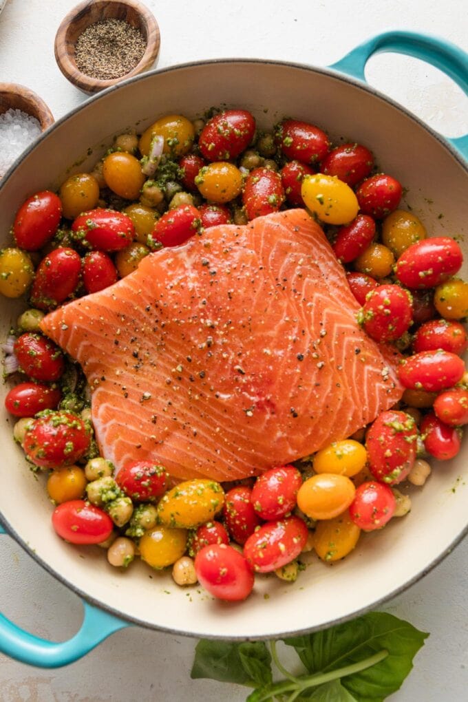 Salmon filet added to the middle of a pan and seasoned lightly with olive oil, salt, and pepper.