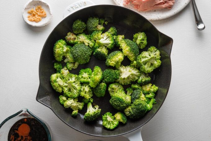 Broccoli florets sauteed in a cast iron skillet.