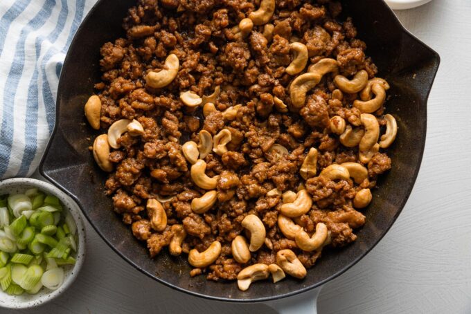 Cashews and ground chicken in a skillet.