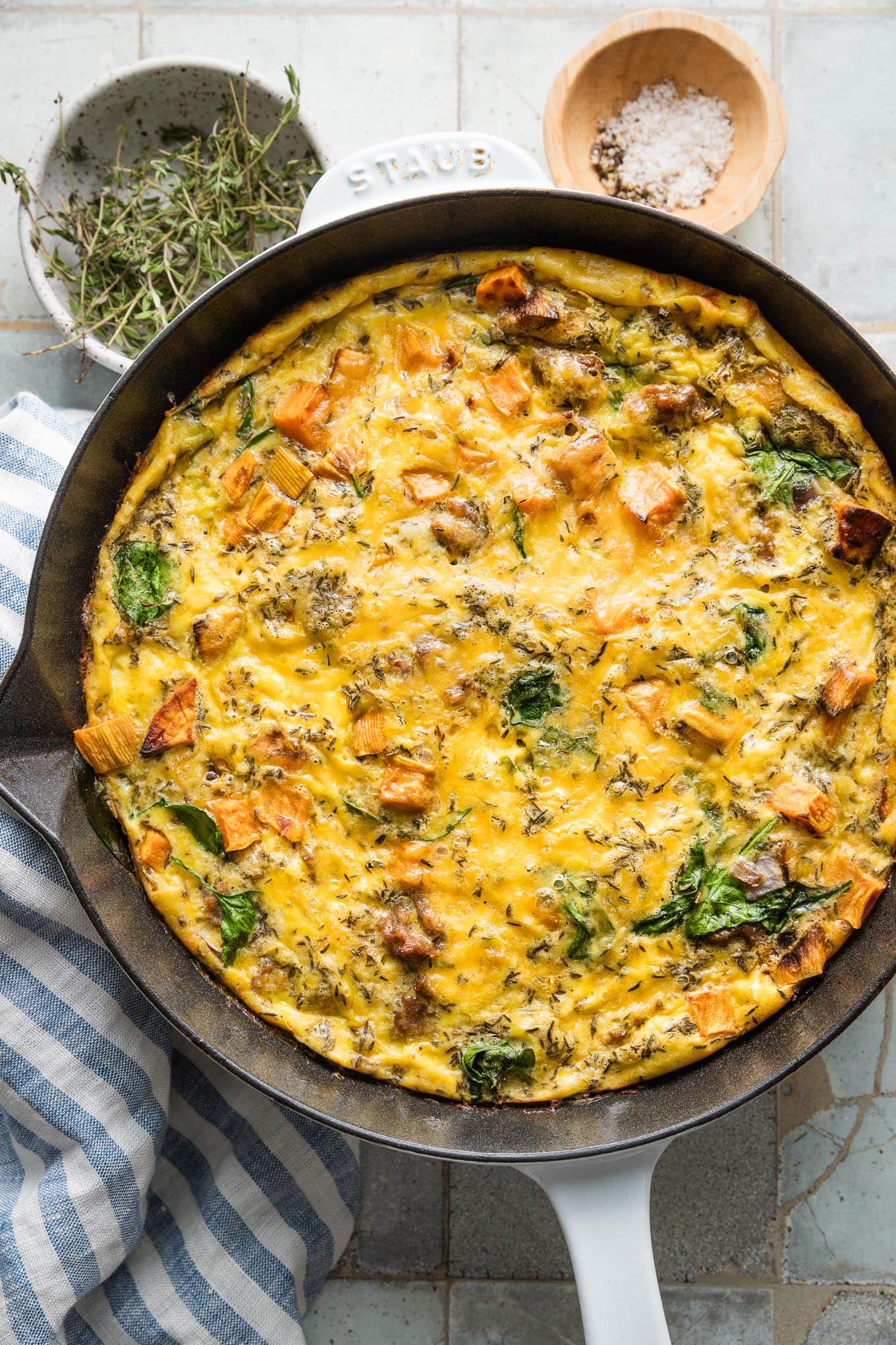 Close up overhead view of a sweet potato sausage frittata just removed from the oven, with cheese and spinach baked in.