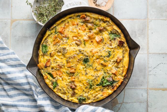 Baked sausage sweet potato frittata cooling on a tile counter.