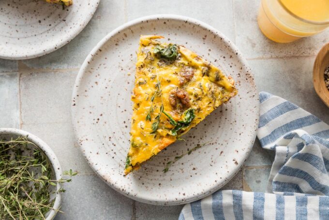 Landscape view of a slice of frittata on a small plate.