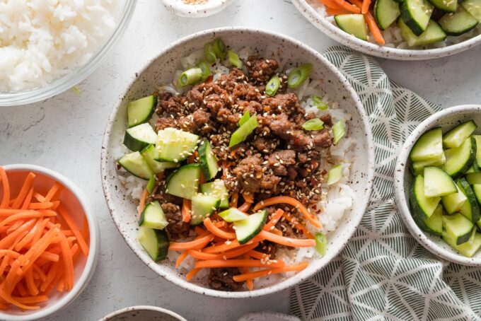 These Korean-inspired ground beef and rice bowls are outrageously easy to make, delicious, and ready in less than 20 minutes. If you're looking for something new to do with ground beef, this is the answer! Top with your favorite veggies and toasted sesame seeds for an easy, vibrant, and flexible dinner.