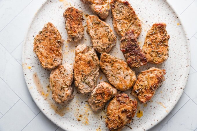 Cooked pork medallions resting on a plate.